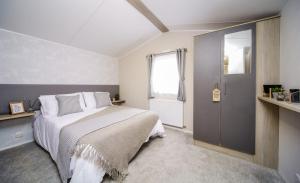 a bedroom with a large bed and a window at Llanrhidian Holiday Park in Llanmorlais