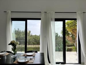 a dining room with a table and a large window at Zeus Holiday Home in Pissouri