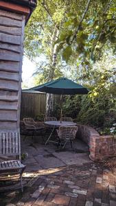 a patio with a table and chairs and an umbrella at The Bristol Coach House in the heart of Bishopston in Bristol