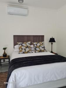 1 dormitorio con 1 cama grande con sábanas y almohadas blancas en Egerton Overnight en Kimberley
