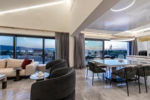 a living room with a couch and a table and chairs at Ilios Villa in Porto Heli