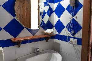 a bathroom with a mirror and a sink at Casale Ginisara in Castellammare del Golfo