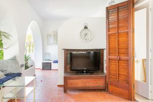 Seaview Villa في سان أنطونيو: غرفة معيشة مع تلفزيون على منصة خشبية