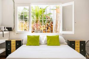 Un dormitorio con una cama con almohadas verdes y una ventana en Seaview Villa en San Antonio