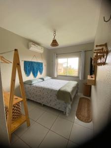 um quarto com uma cama e uma janela em Lindo Flat Na Paradisíaca Praia da Taíba em Taíba
