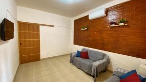 uma sala de estar com um sofá e uma televisão em Casa uma Quadra da Praia das Asturias com área gourmet no Guarujá