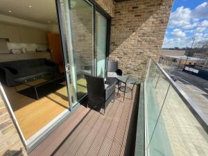 a balcony with a table and chairs and a couch at Luxury London Apartment - Steps To East Croydon Train Station in Croydon