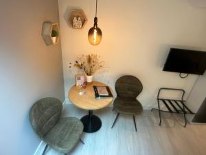 Habitación con mesa, 2 sillas y TV. en Studio Schipper en Alkmaar