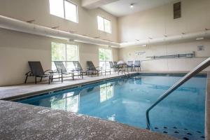 a swimming pool with chairs and a table at Fairfield Inn & Suites by Marriott Knoxville/East in Knoxville