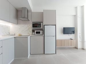 a white kitchen with a refrigerator and a microwave at Apartamento en El Prado in Cullera