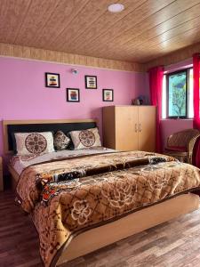 a bedroom with a large bed with pink walls at Kheychun homestay in Darjeeling
