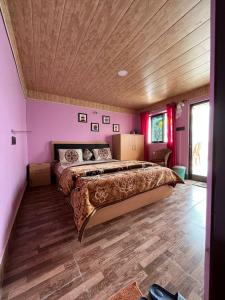 een slaapkamer met een groot bed en een houten plafond bij Kheychun homestay in Darjeeling