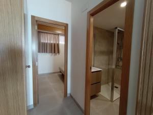 a bathroom with a walk in shower next to a door at Apartamento en El Prado in Cullera +17 photos