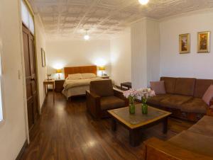 Hotel Inca Real في كوينكا: غرفة معيشة مع أريكة وسرير