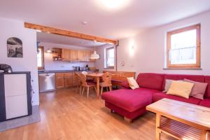 een woonkamer met een rode bank en een tafel bij River Valley View House in Bohinjska Bistrica