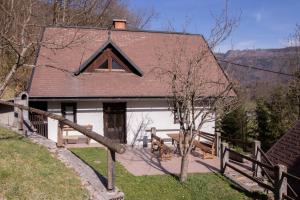 een huis met een tafel en banken ervoor bij River Valley View House in Bohinjska Bistrica