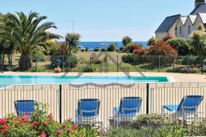 grupa niebieskich krzeseł siedzących obok basenu w obiekcie LocaLise - A06 - Entièrement de plain-pied avec petite vue mer - Donnant sur la piscine et le jardin - wifi inclus - draps inclus - w mieście Guilvinec +37 zdjęć