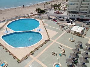 an overhead view of a swimming pool next to the beach at Apartamento en El Prado in Cullera