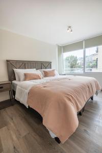 a bedroom with a large bed with a large window at Praia 58 Reñaca in Viña del Mar