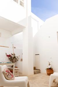 a white room with a white couch and a table at Casa do Almirante in Tavira