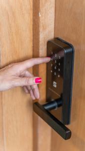 a persons hand pointing to a lightswitch on a door at Praia 58 Reñaca in Viña del Mar