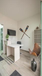 an office with a white desk and a tv and a chair at Praia 58 Reñaca in Viña del Mar