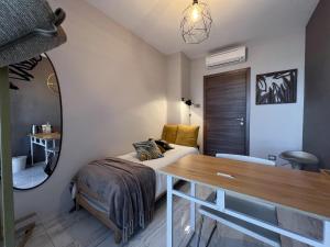 een slaapkamer met een bed, een bureau en een spiegel bij Holy-Day Rooms Milano in Milaan