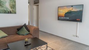 a living room with a couch and a tv on a wall at homy City Diamant in Feldkirch, Grenznähe und doch Zentral in Feldkirch