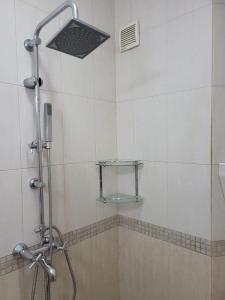 y baño con ducha con cabezal de ducha. en Niya Apartment Bourgas, en Burgas