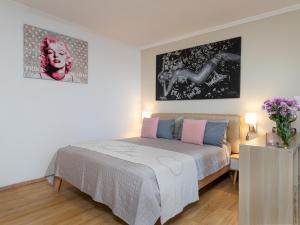 1 dormitorio con 1 cama y pinturas en la pared en Ferienwohnung im Herzen vom Sylt en Westerland