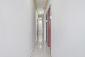 a corridor of a bathroom with a shower stall at SPOT ON Nirvaan Guest House in Kāhārpāra