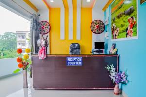 an office with a reception counter with flowers in a room at SPOT ON Nirvaan Guest House in Kāhārpāra