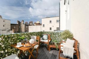 a patio with a table and chairs on a balcony at Central Brighton few Steps from Brunswick Square in Brighton & Hove