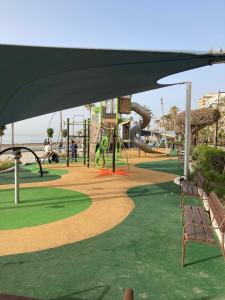 einen Park mit Spielplatz mit Rutsche und Bänken in der Unterkunft Bellavista Costa del Sol in Estepona