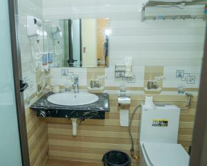 ein Badezimmer mit einem Waschbecken, einem WC und einem Spiegel in der Unterkunft Anh Nhu Hotel in Cát Bà
