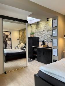 a bedroom with two beds and a stone wall at Studio 20for2 Nähe Köln in Bergisch Gladbach