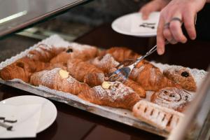 a person is reaching for a tray of pastries at Residenza Radetzky in Milan