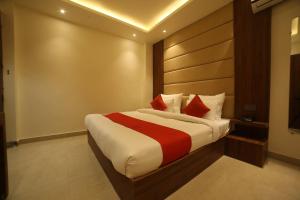 - une chambre avec un grand lit et des oreillers rouges dans l'établissement Super OYO Status Inn, à Dehradun