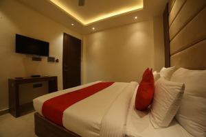 Cette chambre comprend un lit avec des oreillers rouges et blancs. dans l'établissement Super OYO Status Inn, à Dehradun
