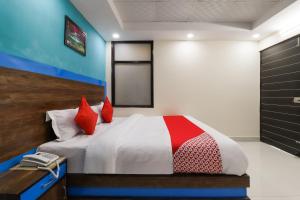 una camera da letto con un letto con cuscini rossi di Flagship Hotel Maharaja Gold a Nuova Delhi
