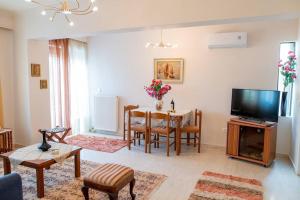 a living room with a table and a television at My Aegean Sea Apartment in Kos Town