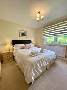 a bedroom with a large white bed and a window at 8 Howrahs Court, Keswick in Keswick