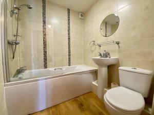 a bathroom with a tub and a toilet and a sink at 8 Howrahs Court, Keswick in Keswick