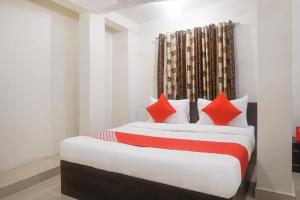 1 dormitorio con 2 camas y almohadas rojas en River View Near Shaniwar Wada, en Pune