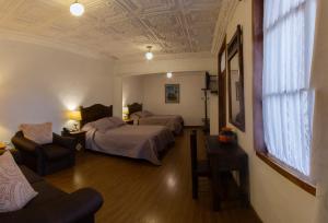 Hotel Inca Real في كوينكا: غرفة فندقية بسريرين واريكة