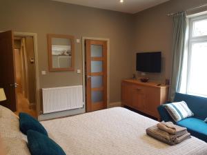 a bedroom with a bed and a television in it at The New Forest Manor Apartment in Lymington