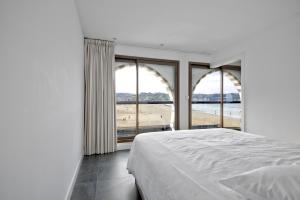 a bedroom with a bed and a view of the ocean at Pavillon Itsasoan in Hendaye