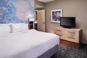 a hotel room with a bed and a flat screen tv at Courtyard Toledo Rossford/Perrysburg in Rossford