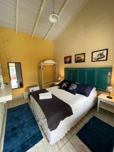 a bedroom with a large bed and two rugs at Hospedaria Gengibre in Barra Velha