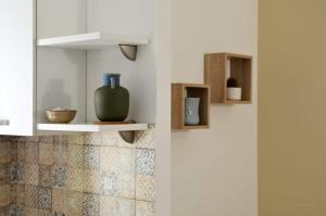 a white kitchen with a vase on a shelf at B&B la Quiete in Leverano